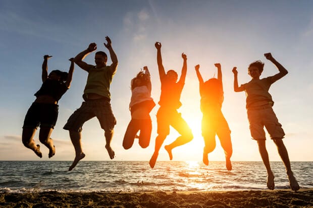 Multiracial Group of People Jumping at Beach, Backlight